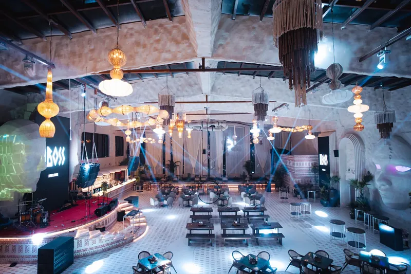 Blue beams crossing the floor at night, the red stage at one end and tasselled chandeliers hanging the length of the room.